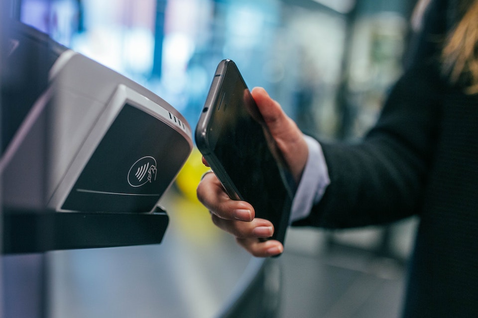 A man uses a phone to make a contactless payment.