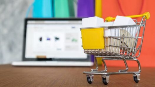 A shopping cart in front of a laptop symbolizes ecommerce