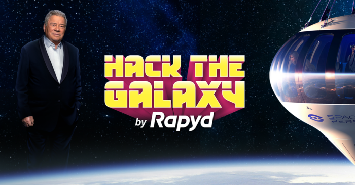 William Shatner standing next to the Hack the Galaxy logo and a space ship...in space!