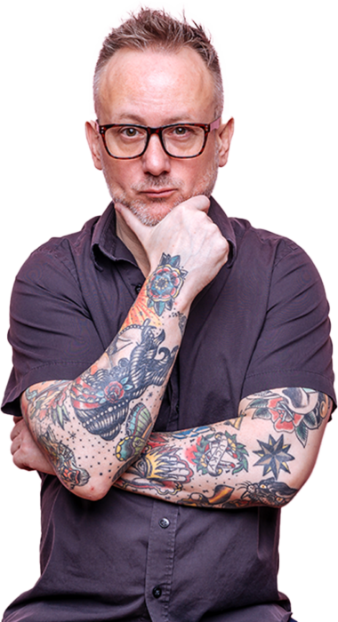 Man wearing glasses holds face with heavily tattooed arms