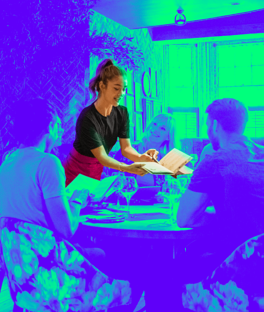 A waitress shows the menu to diners in a restaurant