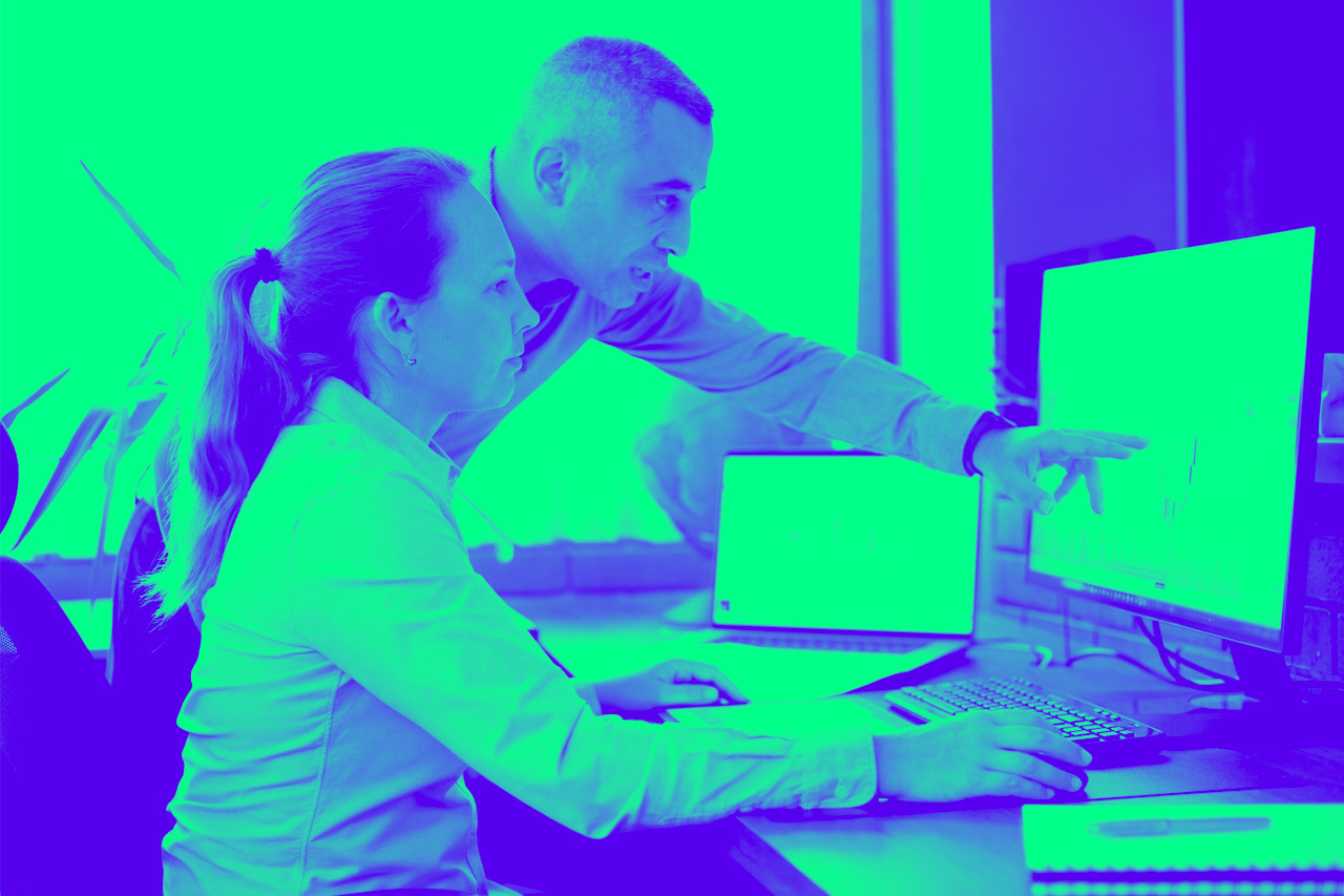 Businesspeople working in the office on stock market exchange data using desktop computer and digital tablet