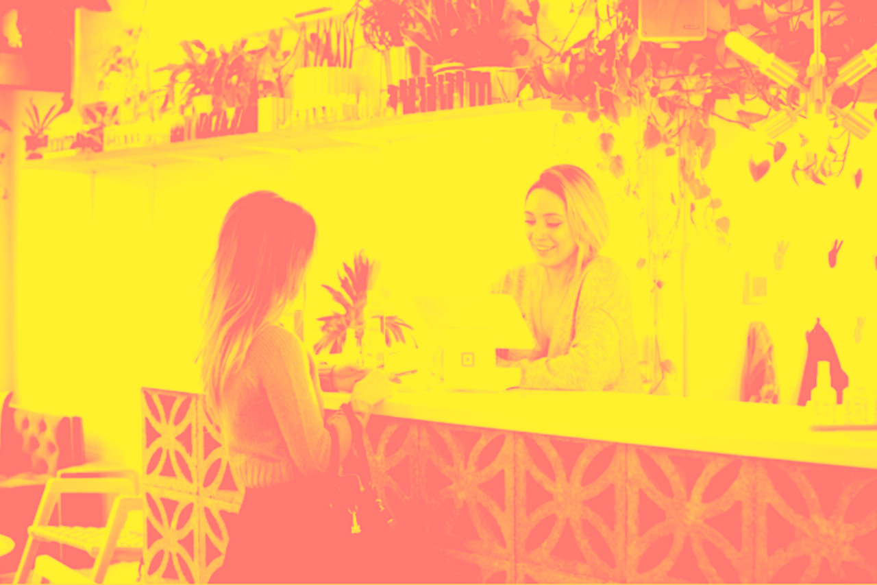 A woman talks to concierge at hotel front desk