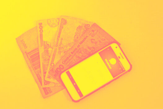 A phone with digital wallet open atop bills from different countries