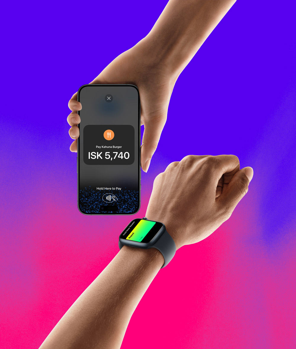 A hand holding an iPhone with a Rapyd credit card is about to pay on an iPhone that has a hold here to pay screen on it.