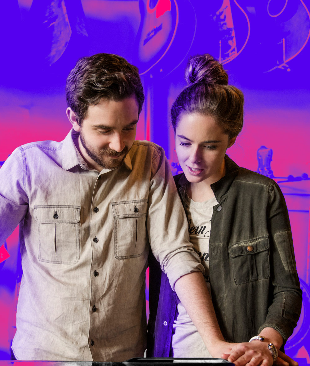 Young couple standing behind counter in music store