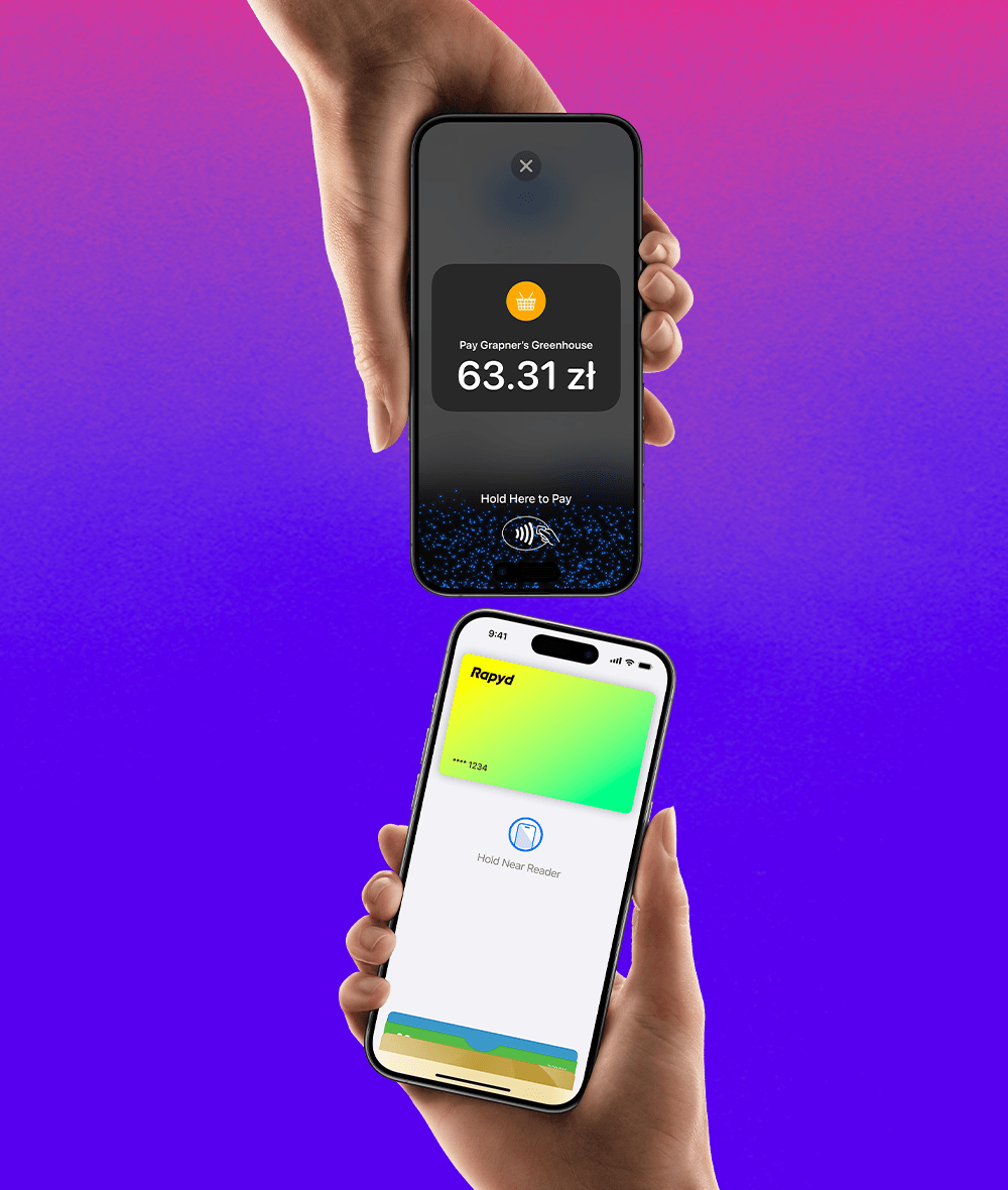 A hand holding an iPhone with a Rapyd credit card is about to pay on an iPhone that has a hold here to pay screen on it.