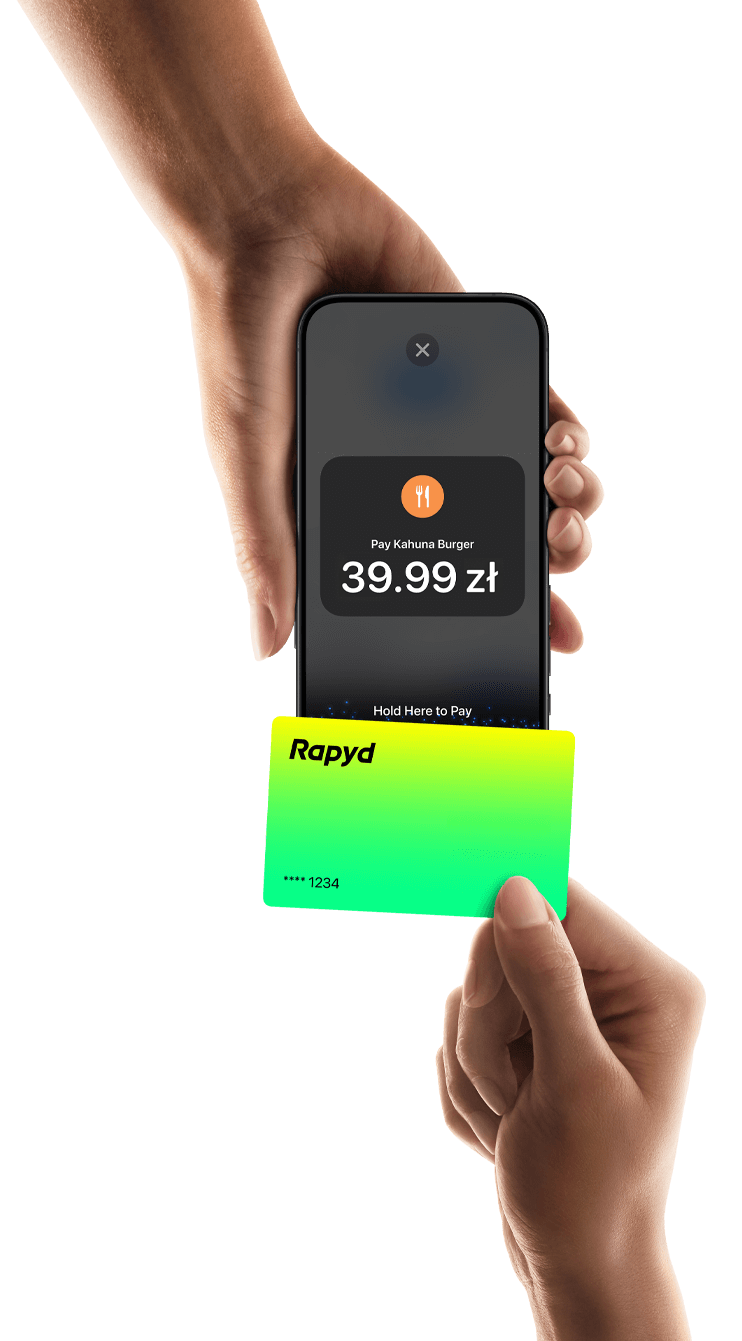 A hand holds a Rapyd credit card and uses tap to pay technology.